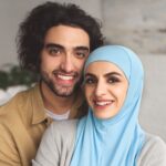 portrait of smiling muslim couple looking at camera at home